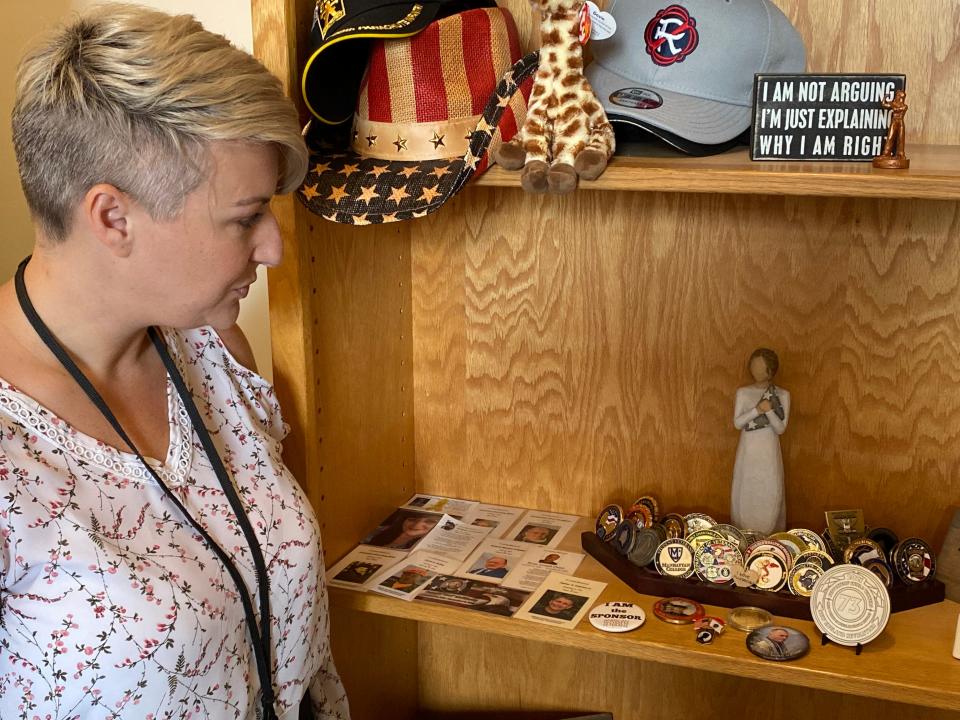 In the office of Taunton's new Veterans Services Director Ally Rodriguez on Wednesday, Aug. 9, 2023, is displayed a coin collection. Each coin was presented to her for various reasons from different organizations over the years for her dedication to veterans services. Also on display are prayer cards of a few veterans she has lost throughout the years. She welcomes any prayer cards family members bring to her.