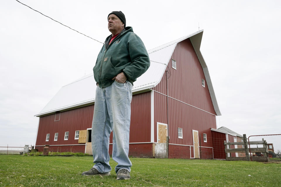 CORRECTS YEARS OF FARMING TO 43 INSTEAD OF 45 - Morey Hill stands near a barn on his farm, Friday, April 16, 2021, near Madrid, Iowa. In 43 years of farming, Hill had seen crop-destroying weather, rock-bottom prices, trade fights and surges in government aid, but not until last year had he endured it all in one season. Now, as Hill and other farmers begin planting the nation's dominant crops of corn and soybeans, they're dealing with another shift _ the strongest prices in years and a chance to put much of the recent stomach-churning uncertainty behind them. (AP Photo/Charlie Neibergall)