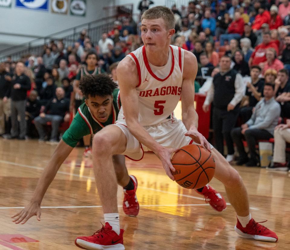 New Palestine High School's Ian Stephens (5) works past a Lawrence North High School defender, at NPHS, Monday, Jan. 30, 2023, during a game won by LNHS, 59-58. 