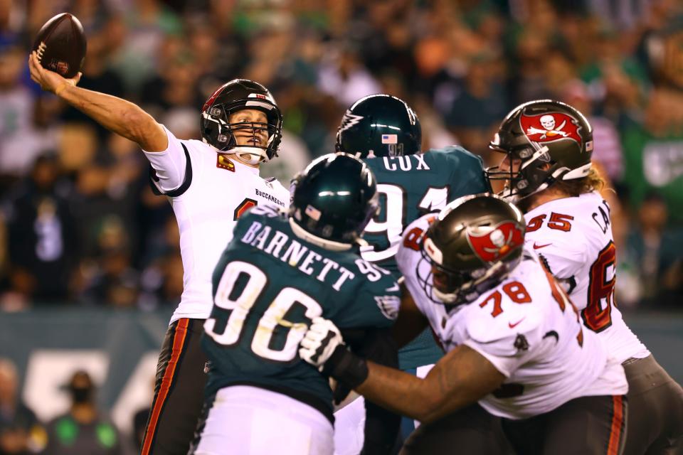 Tampa Bay Buccaneers quarterback Tom Brady (12) looks to pass as Philadelphia Eagles defensive end Derek Barnett (96) and defensive tackle Fletcher Cox (91) apply pressure during an NFL football game, Thursday, Oct. 14, 2021, in Philadelphia. (AP Photo/Rich Schultz)