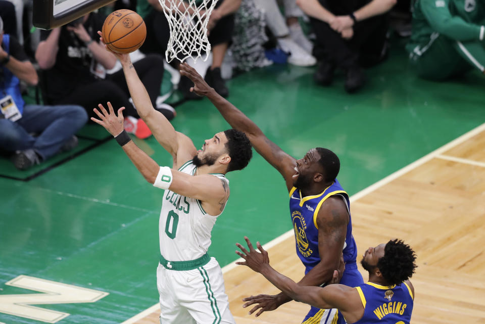 Boston Celtics forward Jayson Tatum (0) puts up a shot against Golden State Warriors forward Draymond Green (23) during the first quarter of Game 6 of basketball's NBA Finals, Thursday, June 16, 2022, in Boston. (AP Photo/Michael Dwyer)