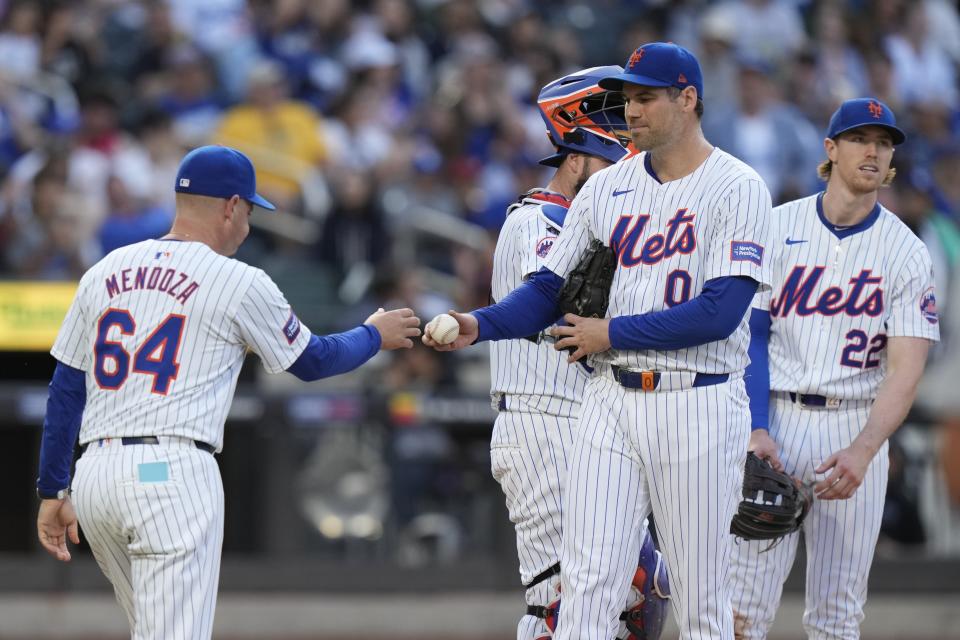 New York Mets pitcher Adam Ottavino (0) hands the ball to New York Mets manager Carlos Mendoza (64) during the eighth inning of a baseball game against the Los Angeles Dodgers, Wednesday, May 29, 2024, in New York. (AP Photo/Frank Franklin II)