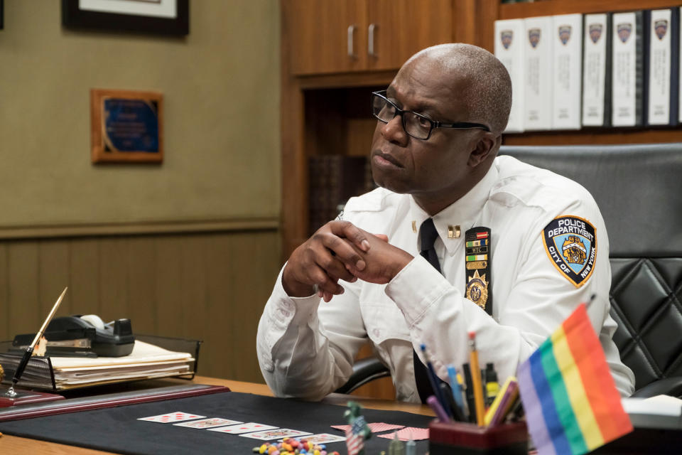 Andre Braugher as Captain Raymond Holt, in police uniform, sits at a desk in an office scene from "Brooklyn Nine-Nine."