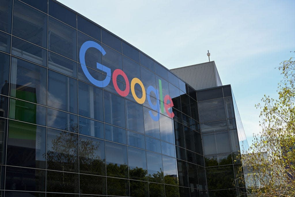 The Google logo is displayed on a dark-colored glass building at Google's headquarters in Mountain View, California.