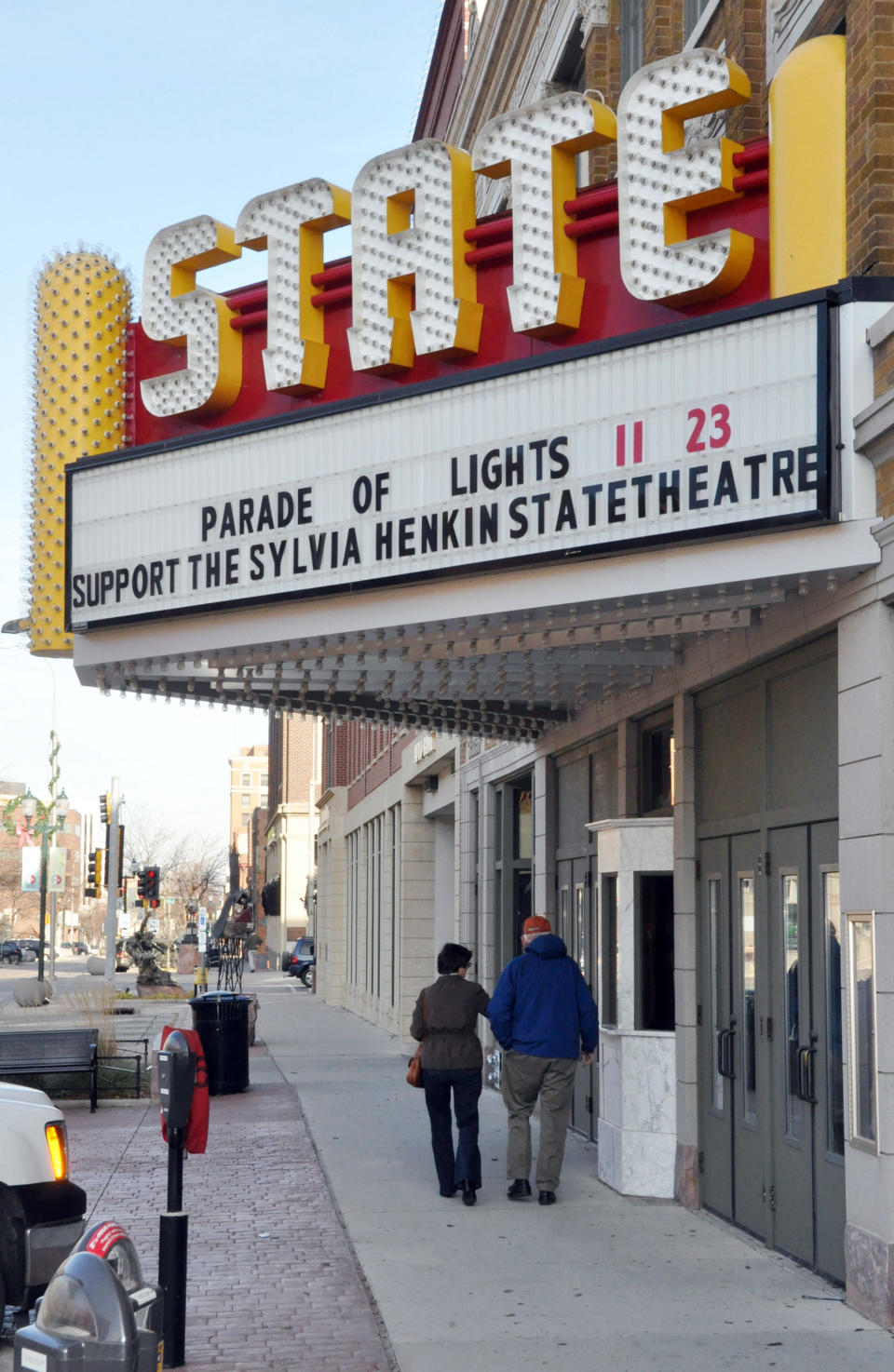 In this Nov. 17, 2012 photo a couple walks under the marquee of the historic downtown State Theatre in Sioux Falls, S.D. The circa-1926 movie house, closed since 1991, has been raising funds for its renovation and plans to begin showing films again in 2013. (AP Photo/Dirk Lammers)