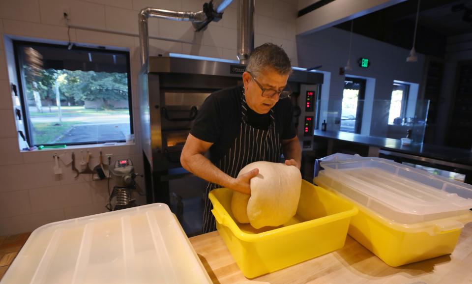 Dan Martello, co-owner of Wildflour, carefully turns a batch dough at the new eatery in the North Winton Village.