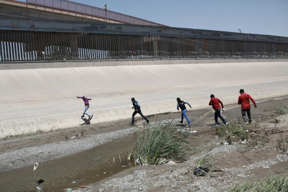 FILE - In this June 15, 2019, file photo, migrants cross the Rio Bravo illegally to surrender to the American authorities, on the U.S.-Mexico border between Ciudad Juarez and El Paso. Hundreds of thousands of people have been arriving at the border in recent months, many of them families fleeing violence and poverty in Central America. Once they reach the border, they can take different paths to try to get into the U.S. (AP Photo/Christian Torres, File)