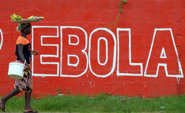 A woman walks past a slogan painted on a wall reading Ebola; in Monrovia, Liberia, on August 31, 2014