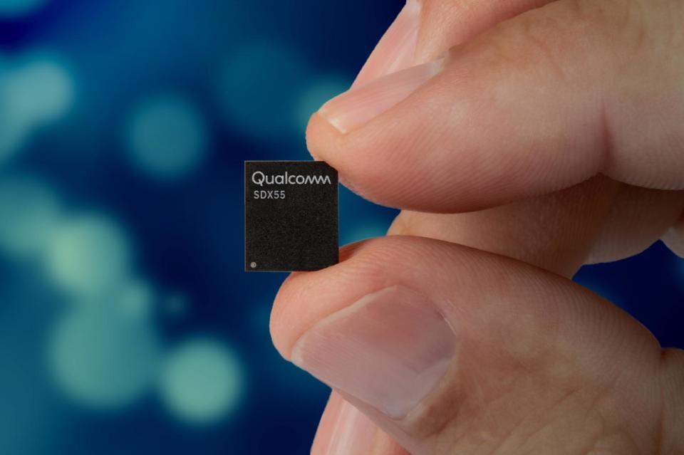 A Snapdragon X55 chip between a person's fingers.