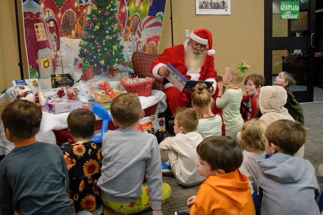 Santa Claus, aka retired Sgt. 1st Class Charles Peters, reads “Twas the Night Before Christmas” to the children attending the U.S. Army Space and Missile Defense Command and Survivor Outreach Services’ Happy Who-liday Party for the family members of fallen service members at the Java Café on Redstone Arsenal, Alabama, Dec. 2, 2023.