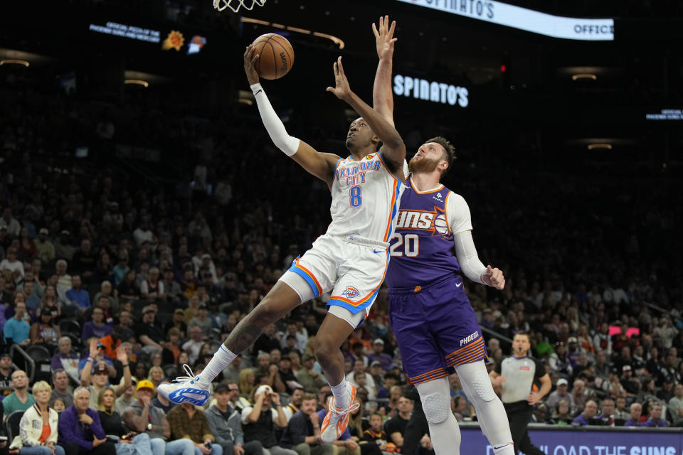 Oklahoma City Thunder forward Jalen Williams drives past Phoenix Suns center Jusuf Nurkic (20) during the first half of an NBA basketball game, Sunday, March 3, 2024, in Phoenix. (AP Photo/Rick Scuteri)