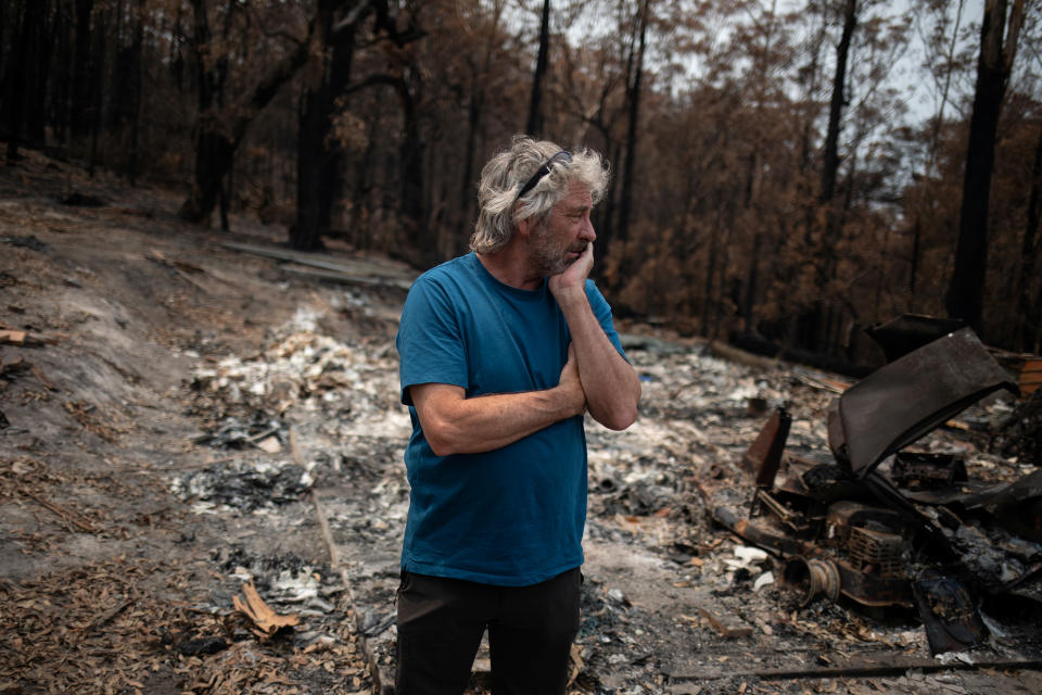 Australian surfer David Ford stands next to a burnt shed where he kept his vintage surfboard collection that was destroyed in the recent bushfires in Lake Conjola