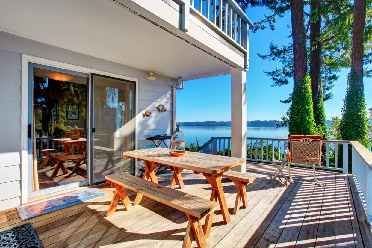 Walkout deck  with wooden table set and amazing water view.