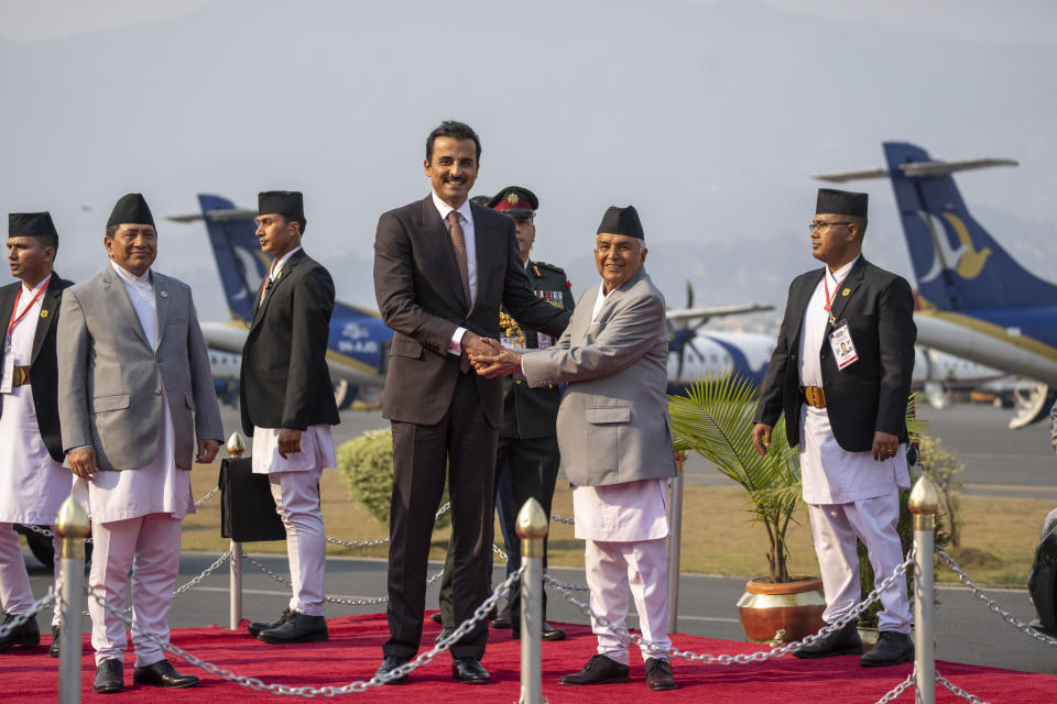 Qatar's Emir Sheikh Tamim bin Hamad Al Thani, is received by Nepal President Ram Chandra Poudel, right as he arrives at the airport in Kathmandu, Nepal, Tuesday, April 23, 2024. The emir is on a two-days visit to the Himalayan nation. (AP Photo/Niranjan Shreshta)