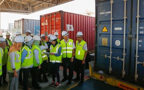 Malaysian officials inspect a container before it is returned to its country of origin - Credit: AFP