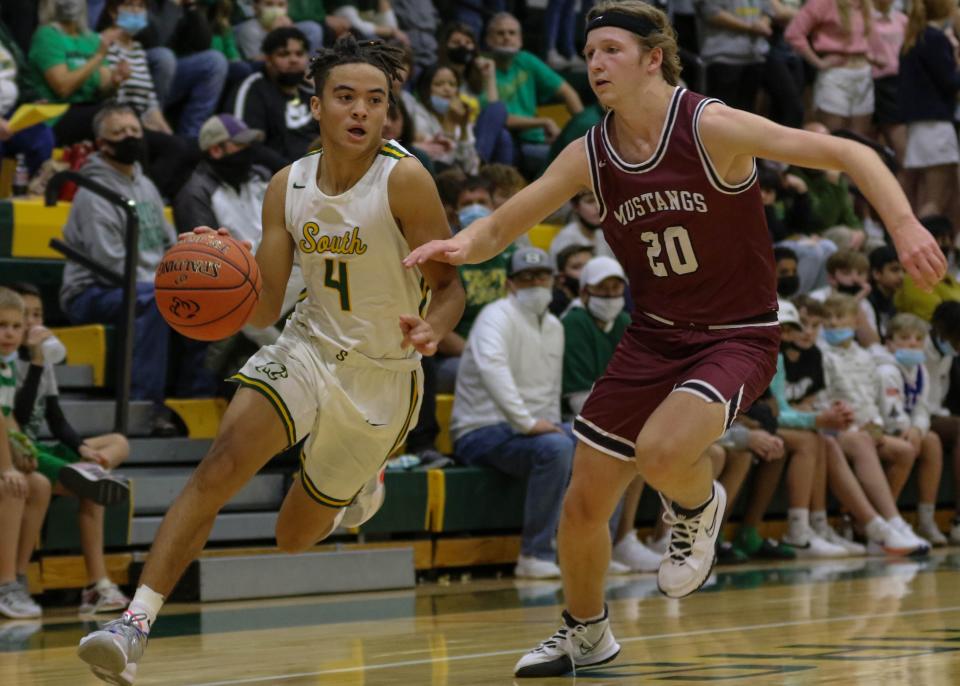 Salina South's Carter Copes (4) goes to the basket while being defended by Salina Central's Dylan Puckett (20) during Friday's game at the South gym.