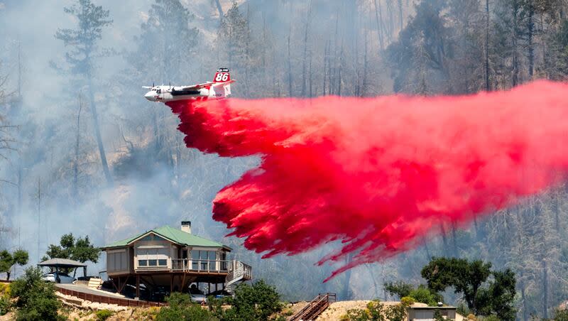 An air tanker drops retardant behind a home while battling the Toll Fire near Calistoga, Calif., Tuesday, July 2, 2024. An extended heat wave blanketing Northern California has resulted in red flag fire warnings and power shutoffs.
