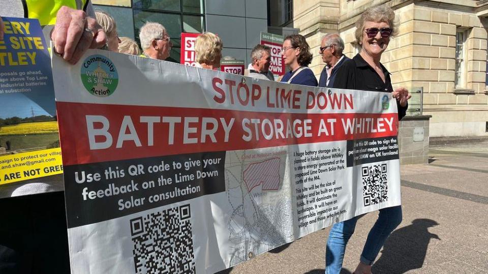 People holding a campaign banner saying 'Stop Lime Down battery storage at Whitley'