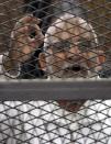 Muslim Brotherhood leader Mohammed Badie shouts slogans from the defendant's cage during his trial with other leaders of the group in a courtroom in Cairo December 11, 2013. Prominent members of the Brotherhood were arrested in a state crackdown on the group following the army overthrow of President Mohamed Mursi and are charged with perpetrating violence during July's clashes. (REUTERS/Stringer)