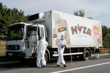 FILE PHOTO - Forensic police officers inspect a parked truck in which migrants were found dead, on a motorway near Parndorf, Austria August 27, 2015. REUTERS/Heinz-Peter Bader/File Photo