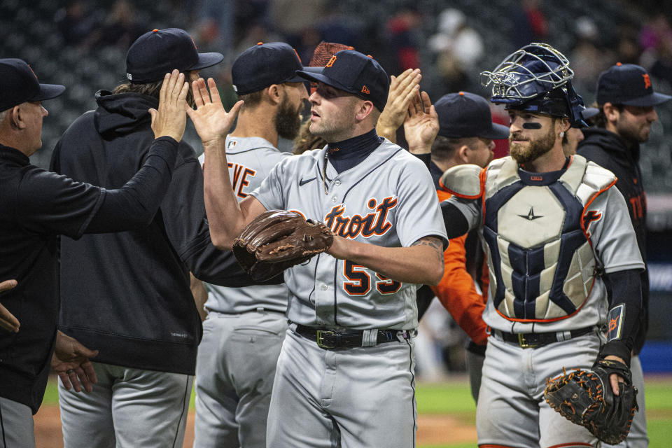 Detroit Tigers relief pitcher Alex Lange (55) and catcher Eric Haase, right, are congratulated by teammates and coaches after a win against the Cleveland Guardians in a baseball game in Cleveland, Monday, May 8, 2023. (AP Photo/Phil Long)