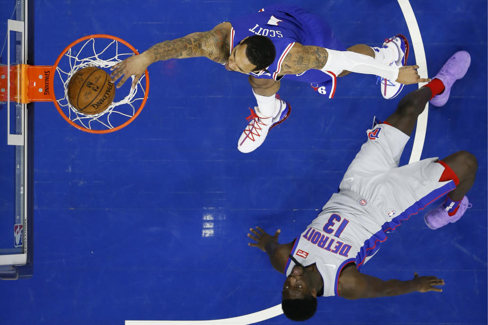 Philadelphia 76ers' Mike Scott (1) goes up for dunk past Detroit Pistons' Khyri Thomas (13) during the first half of an NBA basketball game, Wednesday, March 11, 2020, in Philadelphia. (AP Photo/Matt Slocum)