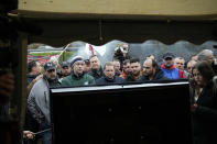 Farmers watch French Prime Minister Gabriel Attal announcing new measures for farmers on a blocked highway, Thursday, Feb.1, 2024 in Chilly-Mazarin, south of Paris. Protests have been held across the EU for most of the week and hundreds of angry farmers driving heavy-duty tractors arrived at European Union headquarters, bent on getting their complaints about excessive costs, rules and bureaucracy heard and fixed by EU leaders at a summit Thursday in Brussels, Belgium. (AP Photo/Christophe Ena)