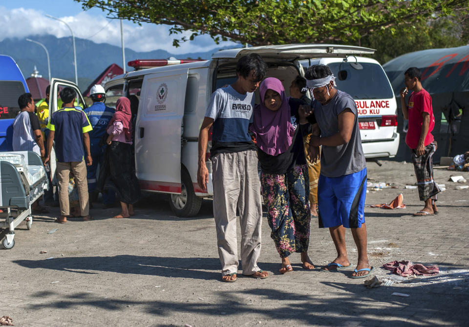 A woman injured in the major earthquake is assisted to a makeshift hospital in Kayangan on Lombok Island, Indonesia, Monday, Aug. 6, 2018. Indonesian authorities said Monday that rescuers still haven't reached some devastated parts of the tourist island of Lombok after the powerful earthquake flattened houses and toppled bridges, killing large number of people and shaking neighboring Bali. (AP Photo/Fauzy Chaniago)