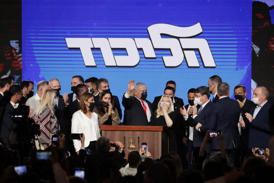 Israeli Prime Minister Benjamin Netanyahu, center, with his party members waves to his supporters after the first exit poll results for the Israeli parliamentary election at his Likud party's headquarters in Jerusalem, Wednesday, March. 24, 2021.(AP Photo/Maya Alleruzzo)