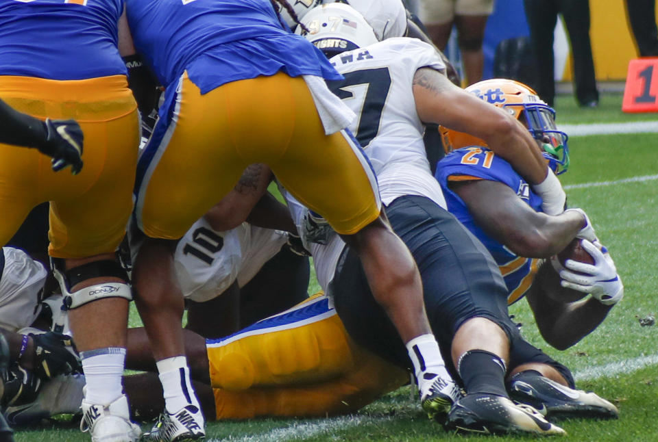 Pittsburgh running back A.J. Davis (21) gets into the end zone past Central Florida defensive lineman Mason Cholewa (97) for a touchdown during the first half of an NCAA college football game, Saturday, Sept. 21, 2019, in Pittsburgh. (AP Photo/Keith Srakocic)