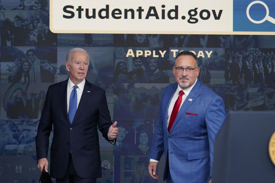 FILE - President Joe Biden answers questions with Education Secretary Miguel Cardona as they leave an event about the student debt relief portal beta test in the South Court Auditorium on the White House complex in Washington, Oct. 17, 2022. The Supreme Court is scheduled to hear arguments Tuesday, Feb. 28, 2023, involving President Joe Biden's debt relief plan that would wipe away up to $20,000 in outstanding student loans. (AP Photo/Susan Walsh, File)