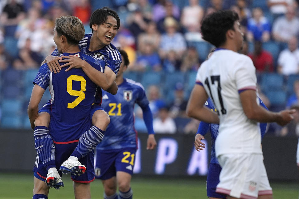 Japan midfielder Koki Saito, back, celebrates with Shota Fujio (9) after Fujio scored a goal on a penalty kick during the first half of an international friendly under-23 soccer match against the United States on Tuesday, June 11, 2024, in Kansas City, Kan. (AP Photo/Charlie Riedel)