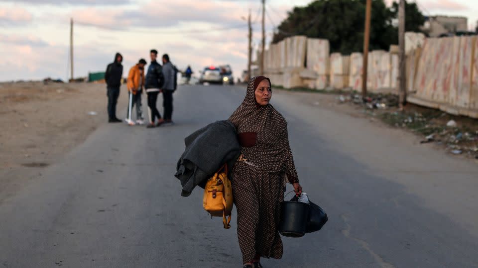 People carry some of their belongings as they walk to Rafah in the southern Gaza Strip on January 4, fleeing central Gaza. - Majdi Fathi/NurPhoto/Getty Images