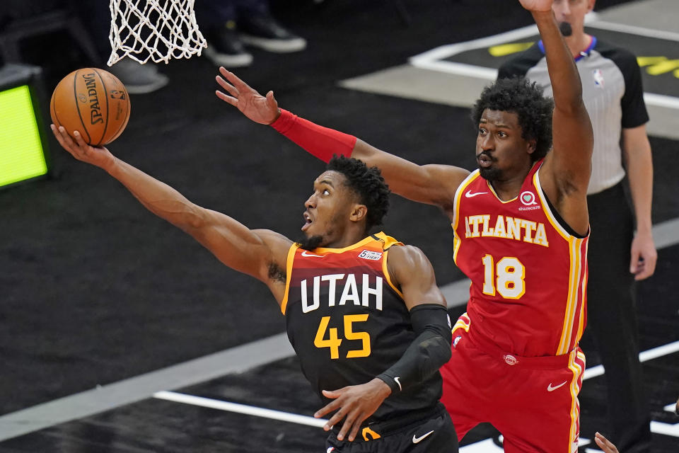 Utah Jazz guard Donovan Mitchell (45) lays the ball up as Atlanta Hawks forward Solomon Hill (18) defends during the first half of an NBA basketball game Friday, Jan. 15, 2021, in Salt Lake City. (AP Photo/Rick Bowmer)