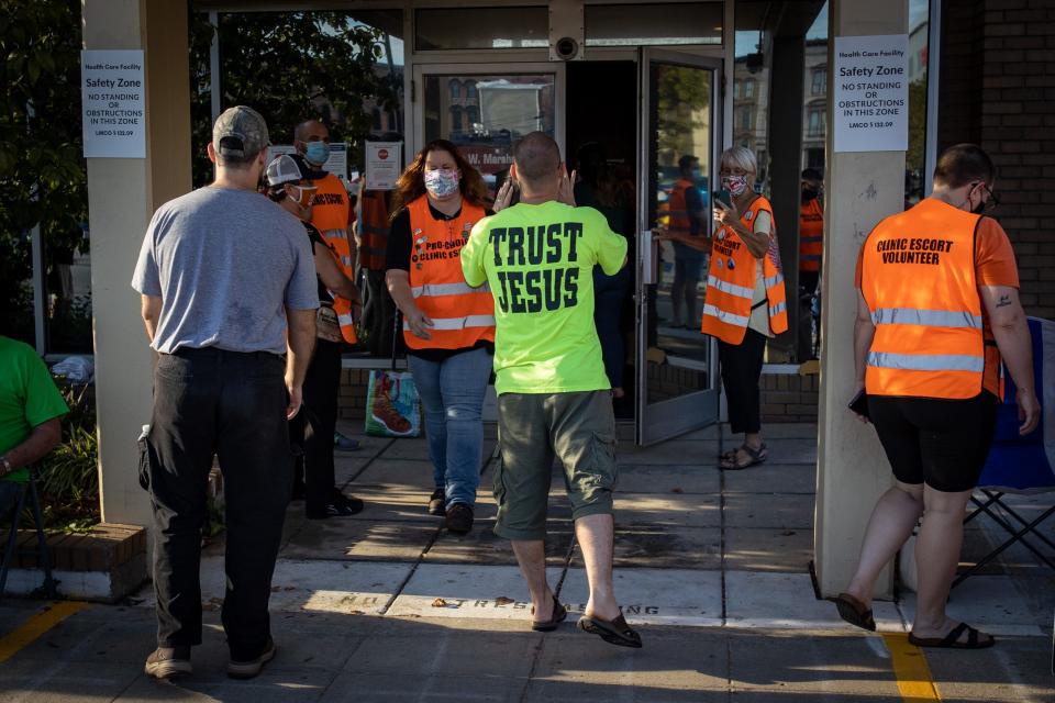 Anti-abortion protesters walk into the restricted safety zone space outside the EMW Women's Surgical Center facility on West Market Street, shouting at patients and others entering the building. Sept. 18, 2021