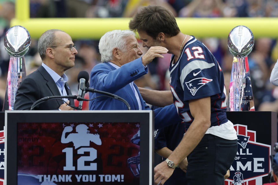 Former New England Patriots quarterback Tom Brady, right, embraces Patriots owner Robert Kraft, center, as Patriots President Jonathan Kraft, left, looks on during halftime ceremonies held to honor Brady at an NFL football game between the Philadelphia Eagles and the Patriots, Sunday, Sept. 10, 2023, in Foxborough, Mass. (AP Photo/Mark Stockwell)