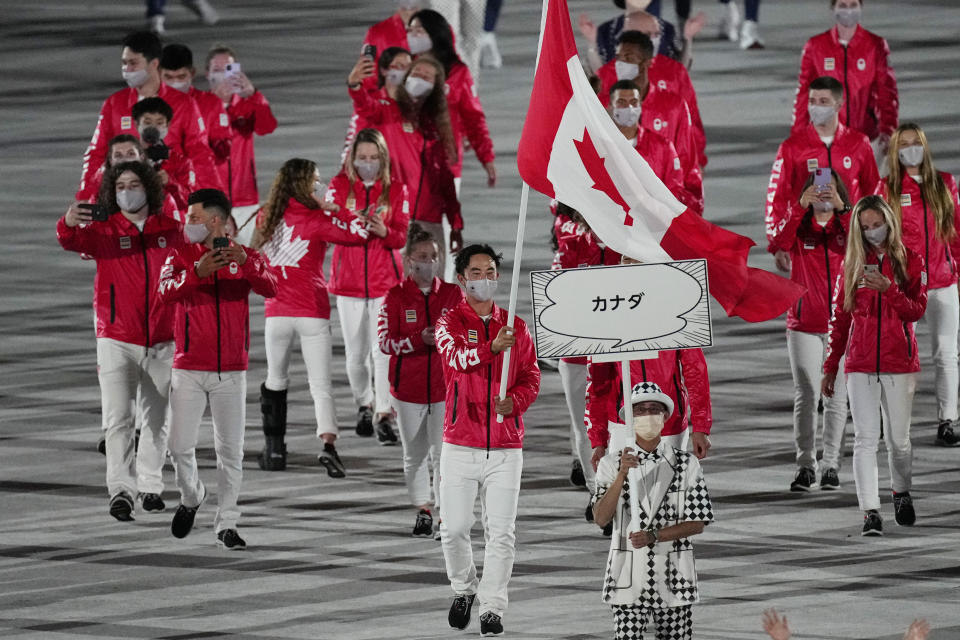 Miranda Ayim and Nathan Hirayama, of Canada, carry their country's flag during the opening ceremony in the Olympic Stadium at the 2020 Summer Olympics, Friday, July 23, 2021, in Tokyo, Japan. (AP Photo/David J. Phillip)