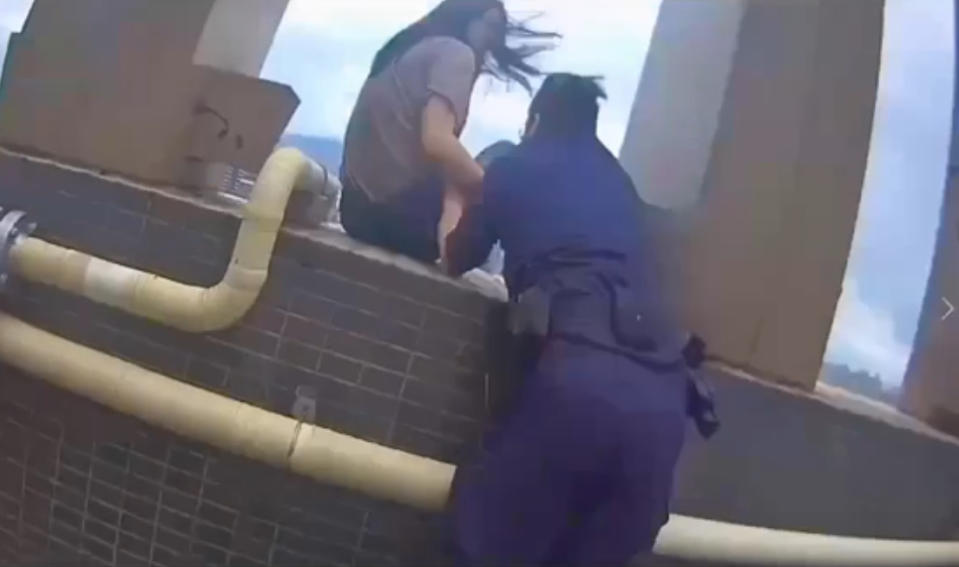 員警抓住女子拉下圍牆化解危機。（圖／翻攝畫面）