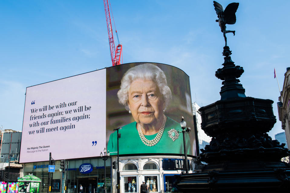 LONDON, ENGLAND - APRIL 10: An image of Queen Elizabeth II and quotes from her broadcast to the nation in relation to the coronavirus epidemic are displayed on screens in Piccadilly Circus on April 10, 2020 in London, England. (Photo by Samir Hussein/WireImage,)