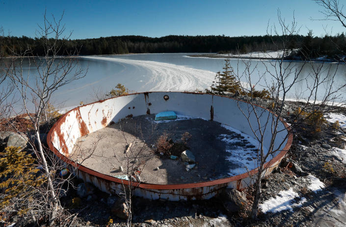 A deteriorating tank sits on the site of the Callahan Mine in Brooksville, Maine, on Dec. 21, 2016. The former open pit copper and zinc mine is now a federal Superfund site. Mining companies that once pursued precious metals have abandoned half a million mines across the country and, thanks to decades of lax regulations, left the bill to taxpayers.<span class="copyright">Robert F. Bukaty—AP</span>