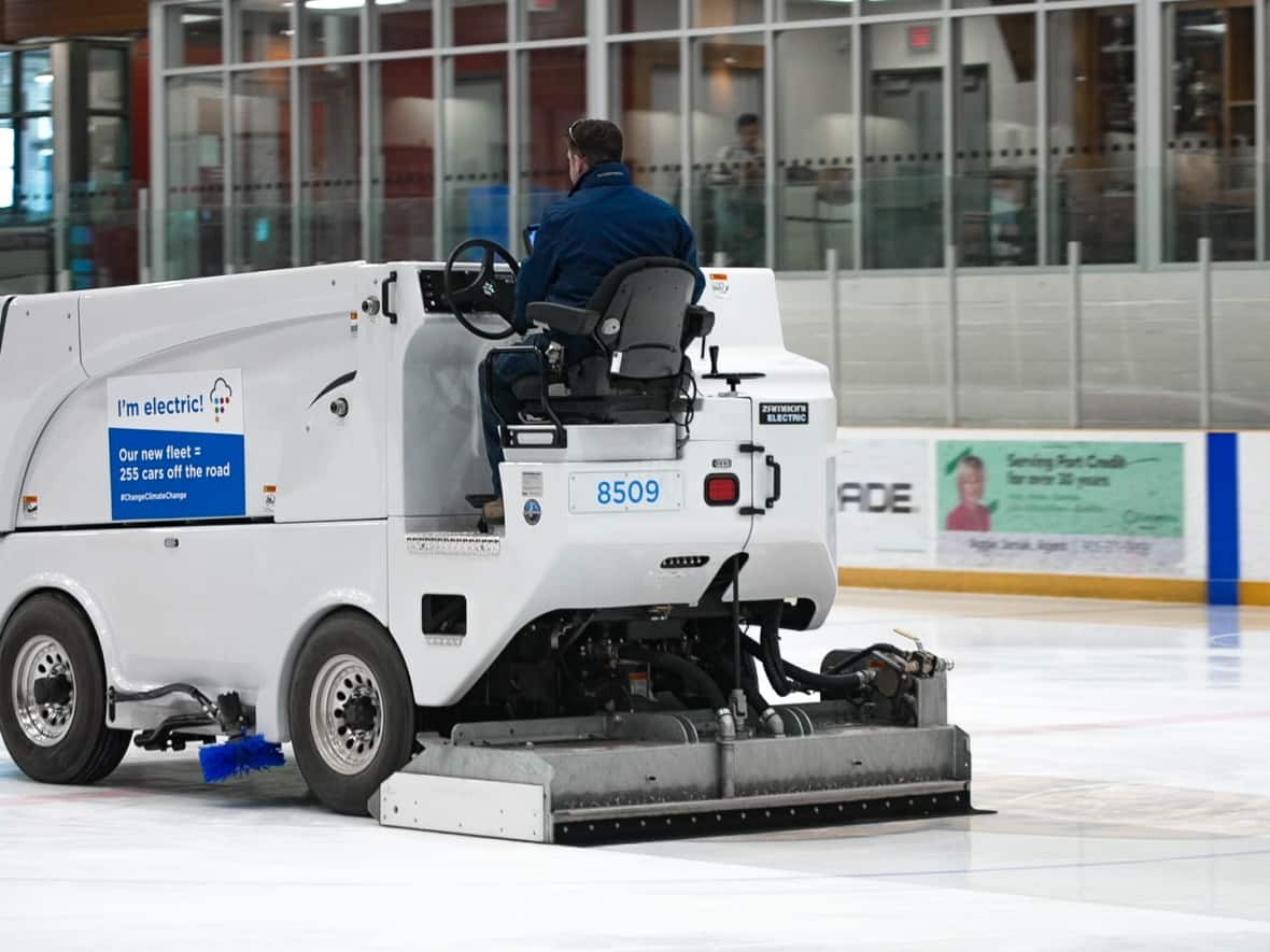 Jeff Cuddy drives the electric Zamboni ice resurfacer at Port Credit Memorial Arena in Mississauga, Ont. The city has electrified about half its fleet of ice resurfacers as part of its climate change plan.  (Craig Chivers/CBC - image credit)