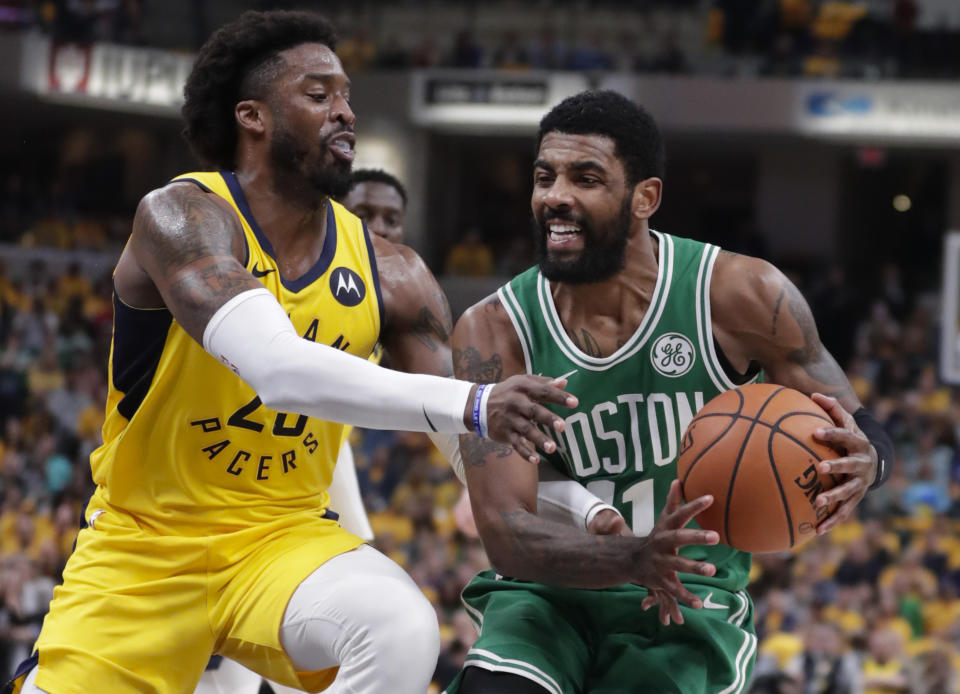 Boston Celtics guard Kyrie Irving, right, is fouled by Indiana Pacers guard Wesley Matthews, left,during the first half of Game 4 of an NBA basketball first-round playoff series in Indianapolis, Sunday, April 21, 2019. (AP Photo/Michael Conroy)