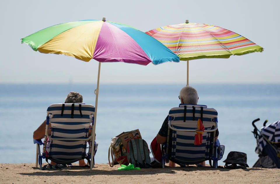 <p>People sit under umbrallas as they enjoy the hot weather at Bournemouth Beach in Dorset. Picture date: Tuesday July 20, 2021.</p>
