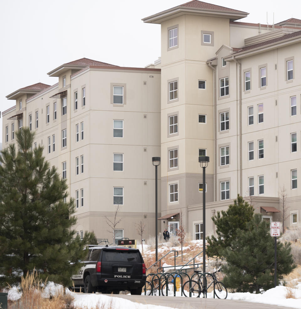 A police officer stands outside a dorm in the Village at Alpine Valley housing, Friday, Feb. 16, 2024, as police investigate a shooting on the University of Colorado Colorado Springs campus in Colorado Springs, Colo. (Christian Murdock/The Gazette via AP)