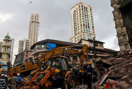 Firefighters and rescue workers search for survivors at the site of a collapsed building in Mumbai, August 31, 2017. REUTERS/Shailesh Andrade