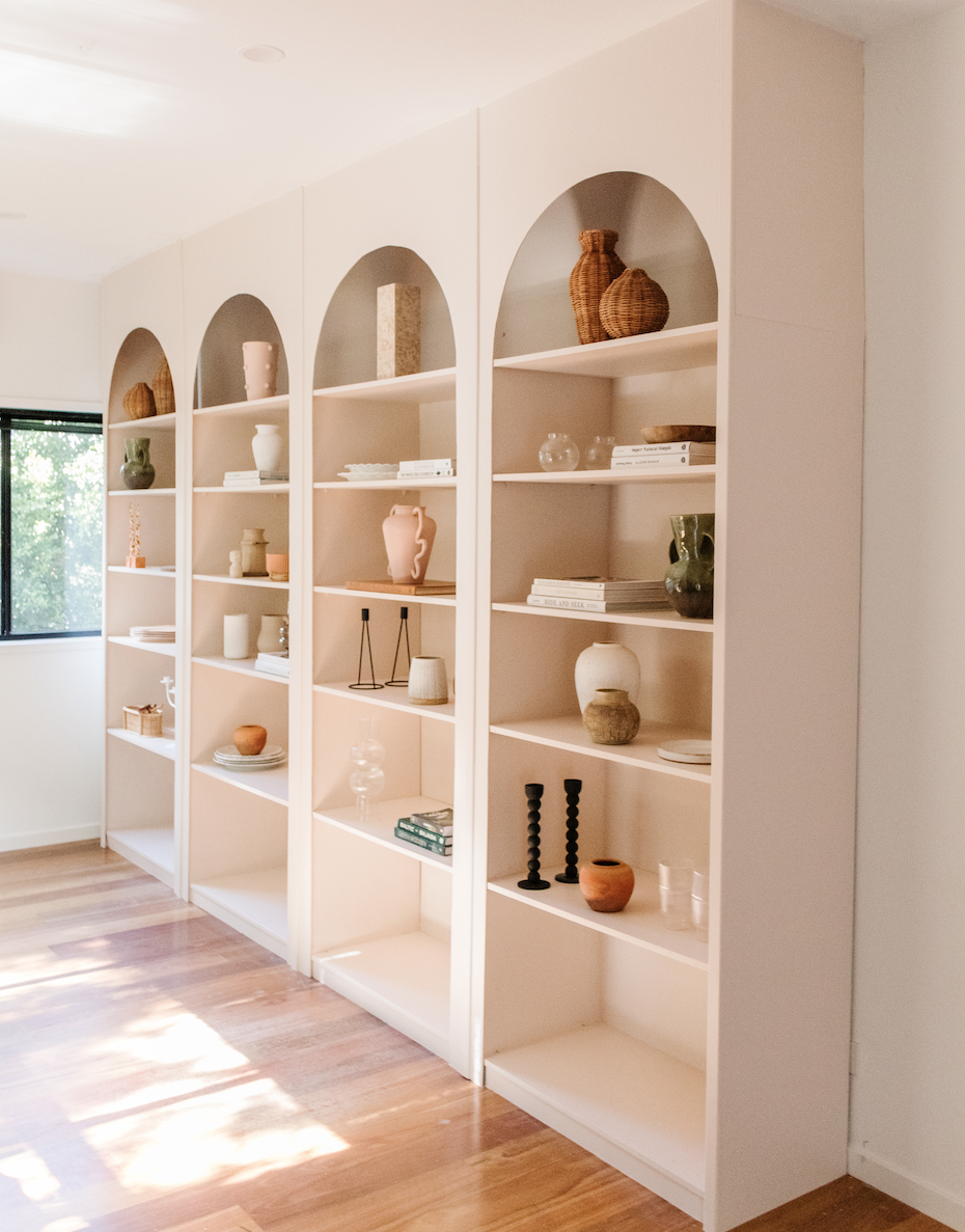 a white shelving unit with white shelves and white walls