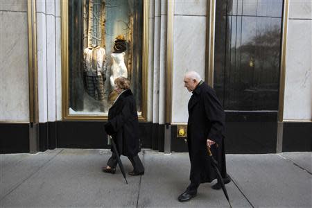 A couple walks past holiday windows displays at the Bergdorf Goodman store in New York, November 22, 2013. REUTERS/Lucas Jackson