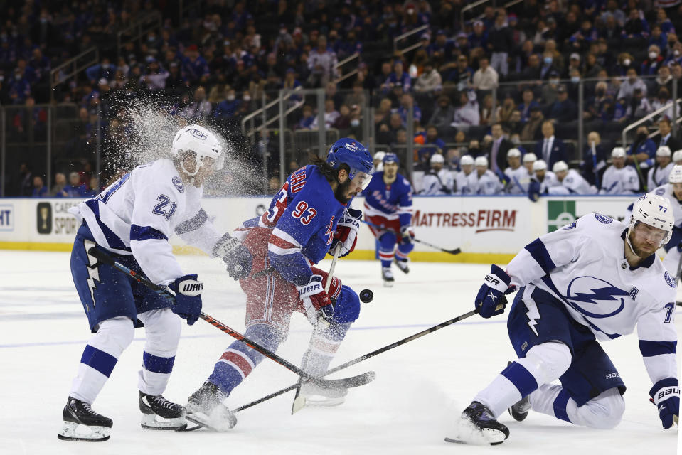 New York Rangers center Mika Zibanejad (93) battles for the puck between Tampa Bay Lightning center Brayden Point (21) and defenseman Victor Hedman (77) during the second period of an NHL hockey game, Sunday, Jan 2, 2022, at Madison Square Garden in New York. (AP Photo/Rich Schultz)