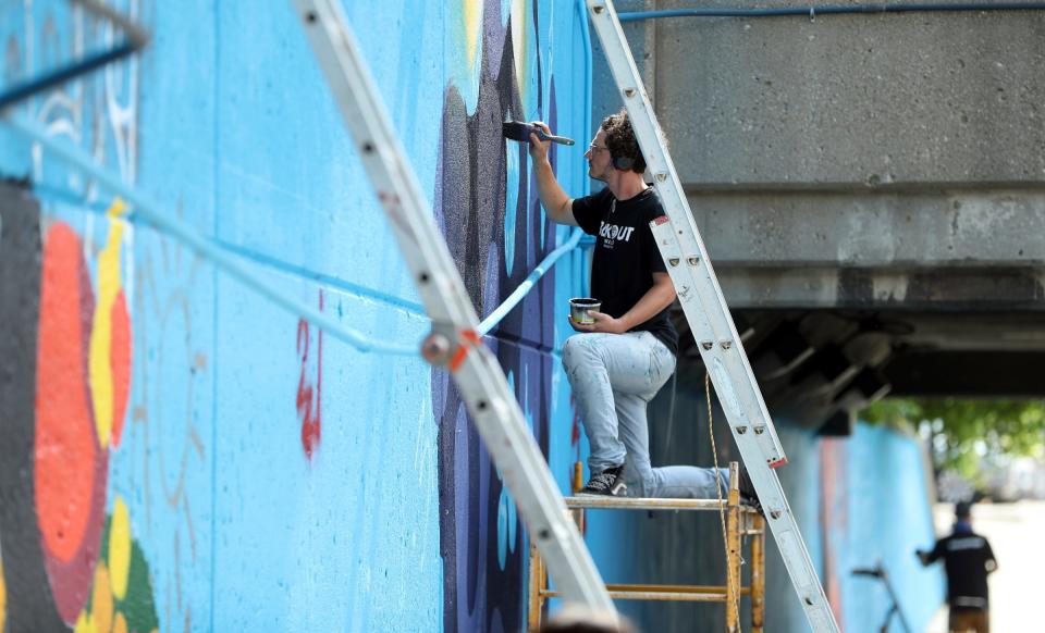 The BLKOUT Mural Festival hosted local and national artists along with some from the International scene to work on 25 murals around metro Detroit Monday, September 11, 2023. Amadeus Roy from Harper Woods works on his mural Friendly Neighborhood Nomad along Woodward Ave.