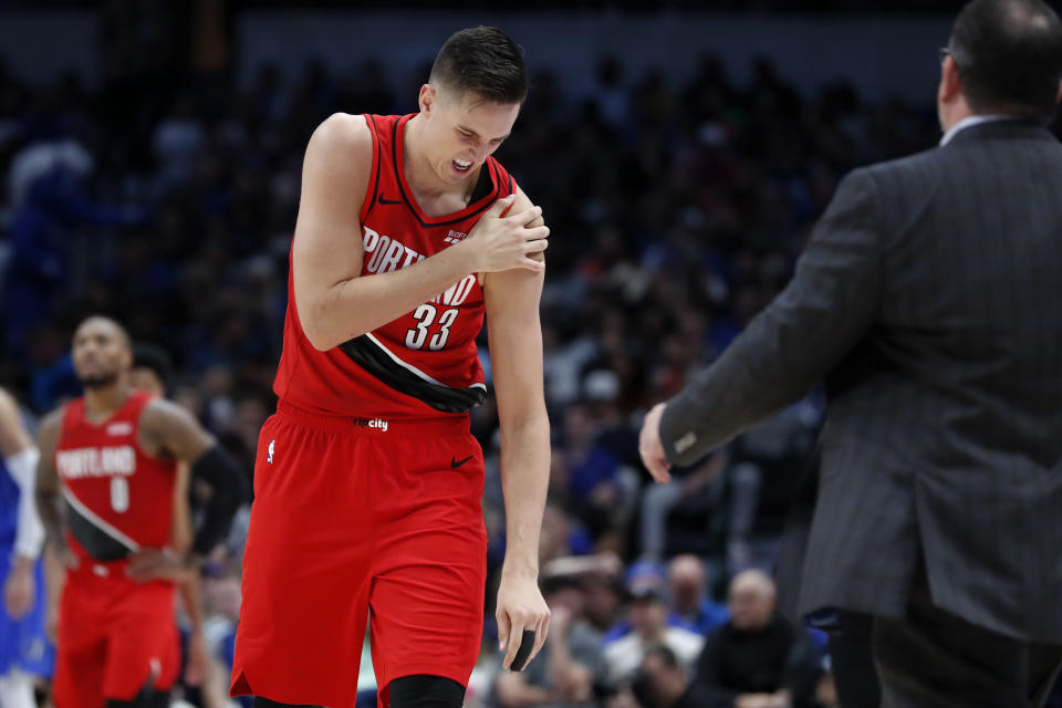 FILE - In this Oct. 27, 2019, file photo, Portland Trail Blazers forward Zach Collins (33) holds his left shoulder as he walks to the bench for assistance after suffering an unknown injury in the second half of an NBA basketball game against the Dallas Mavericks in Dallas. Jusuf Nurkic is back and healthy. So are Zach Collins, Meyers Leonard, Giannis Antetokounmpo, Anthony Davis and plenty of others. If the four-month NBA shutdown had a silver lining, it’s that a lot of ailing players got well. (AP Photo/Tony Gutierrez, File)